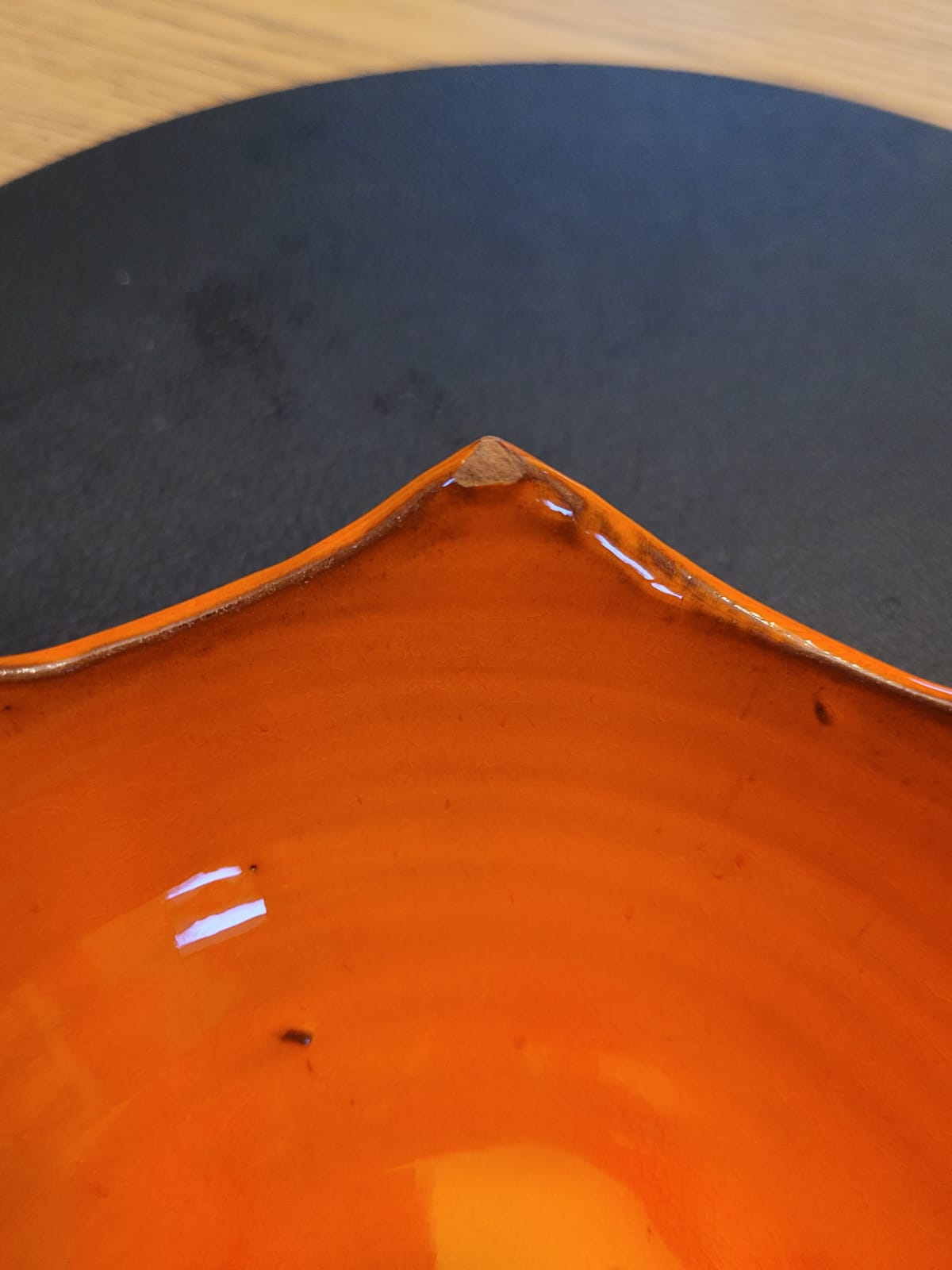 Taza de bolsillo vacía de cerámica naranja.