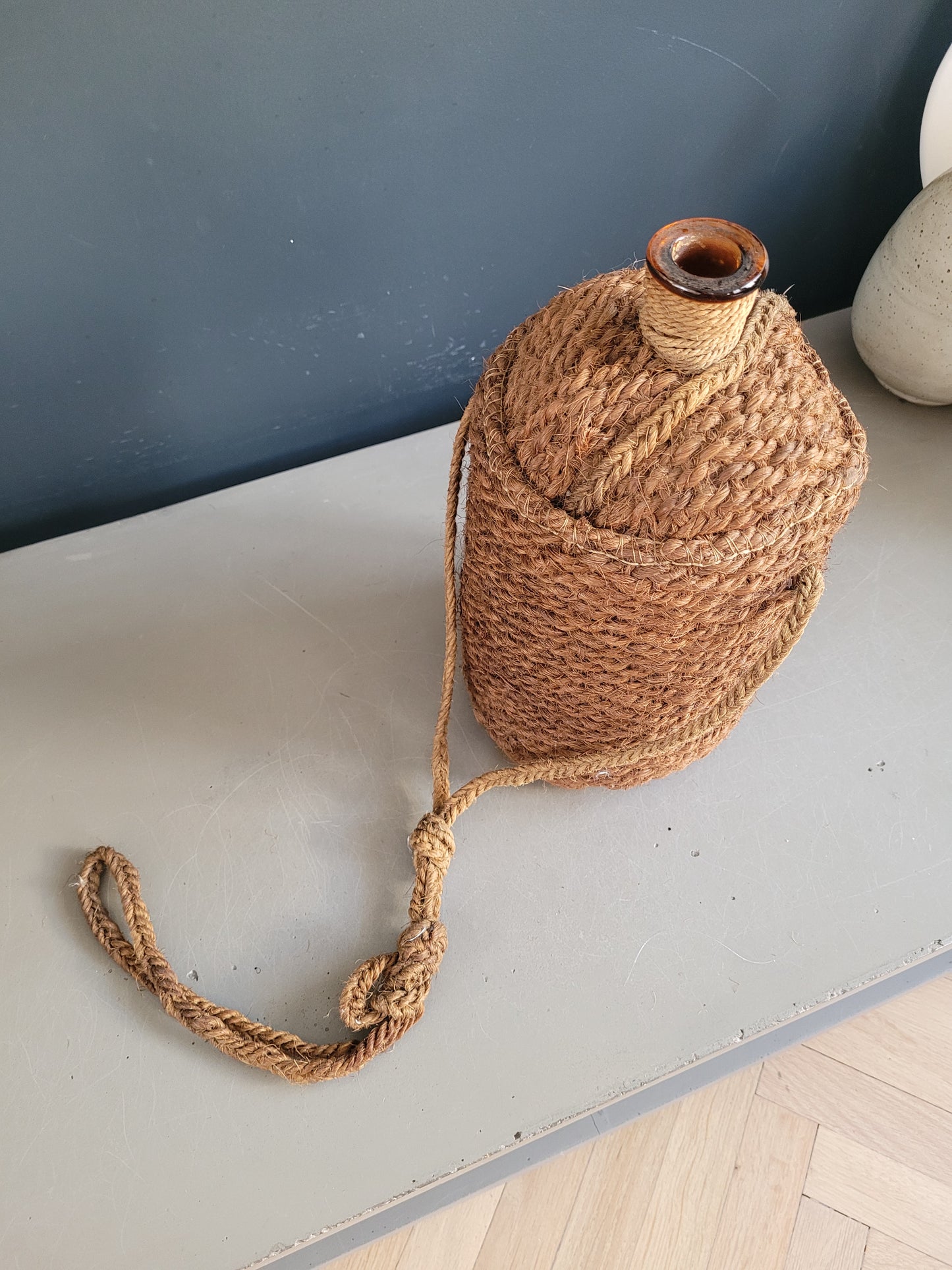 Bouteille ancienne en verre ambré et sac de transport en chanvre - Ref 657