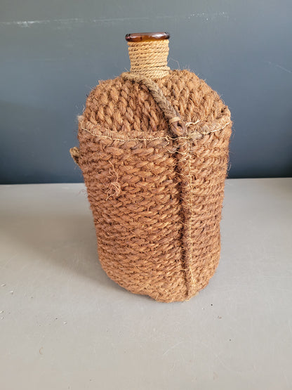 Bouteille ancienne en verre ambré et sac de transport en chanvre - Ref 657