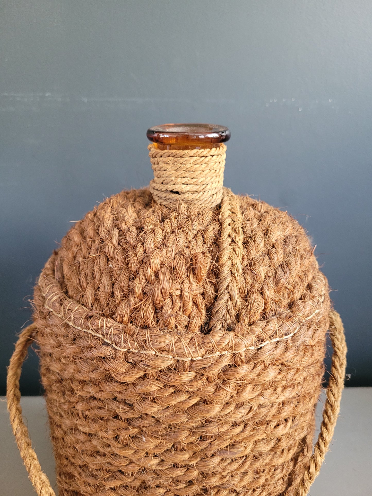 Bouteille ancienne en verre ambré et sac de transport en chanvre - Ref 657