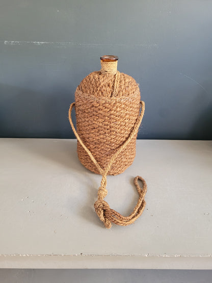 Bouteille ancienne en verre ambré et sac de transport en chanvre - Ref 657